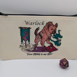 May include: A white canvas zippered pouch with a black zipper. The pouch has a printed image of a hyena with a purple and green background. The text "Warlock" and "Your BBEG is my BFF" is printed on the pouch. A purple and gold 20-sided die is in the foreground.