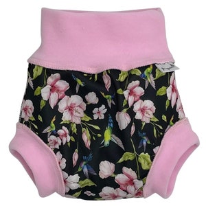 May include: Pink and black reusable cloth diaper with a floral print featuring pink flowers and green hummingbirds. The diaper has a pink fleece lining.