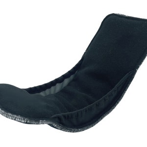 May include: Black cloth nappy insert with a soft, absorbent texture. The insert is designed to fit inside a cloth nappy cover.