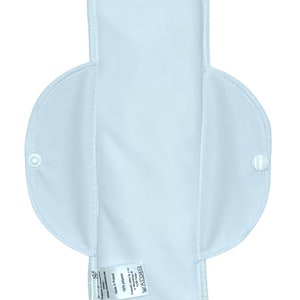 Puede incluir: Compresa menstrual de tela blanca reutilizable con cierre de presión a cada lado. La compresa está hecha de 100% poliéster y está fabricada en Polonia. La etiqueta dice "BEDOY" y "100% Poliéster Hecho en Polonia Lavable a 60°C (140°F)  No blanquear No secar en secadora Planchar a temperatura media No limpiar en seco."