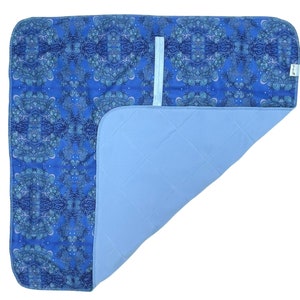 Peut inclure: Un protège-matelas imperméable bleu et blanc à motifs avec un dos matelassé bleu. Le protège-matelas a une poche sur le dessus pour maintenir une feuille ajustée.
