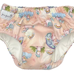 May include: Pink swim nappy with a unicorn and rainbow print. The nappy has a white lining and the text "pupus" on the side.
