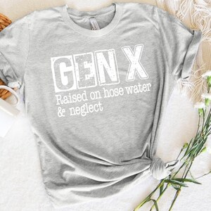 Puede incluir: Camiseta gris con texto blanco que dice "GEN X Raised on hose water & neglect"