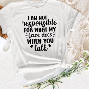 May include: White t-shirt with black text that reads "I am not responsible for what my face does when you talk".