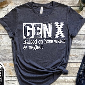 Puede incluir: Una camiseta gris oscuro con texto blanco que dice "GEN X Raised on hose water & neglect".