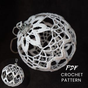 May include: White crochet Christmas ornament with a delicate openwork design. The ornament has a silver cap and a loop for hanging. The text "PDF CROCHET PATTERN" is visible in the lower right corner. The ornament is set against a dark background.