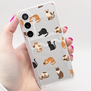 May include: Transparent phone case featuring a repeating pattern of cat illustrations in orange, black, brown, and white. The case has a card slot and camera cutouts.