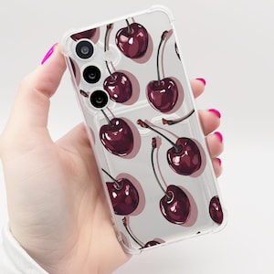 May include: Transparent phone case with a repeating pattern of dark red cherries and green stalks. The case allows the phone's design to be visible. The cherries are evenly distributed across the surface.