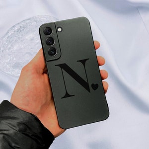 Op de afbeelding: Een zwarte telefoonhoes met een zwarte letter N en een klein hartje ernaast.