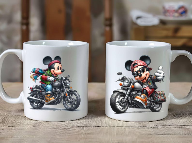 May include: Two white ceramic mugs with a motorcycle and Mickey Mouse design. The mug on the left features Mickey Mouse riding a motorcycle with a blue and green scarf. The mug on the right features Mickey Mouse riding a motorcycle with a red and black bandana.