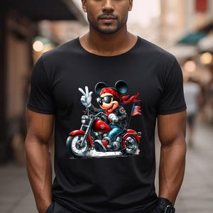 May include: Black t-shirt featuring a cartoon illustration of Mickey Mouse wearing sunglasses and a bandana, riding a motorcycle.