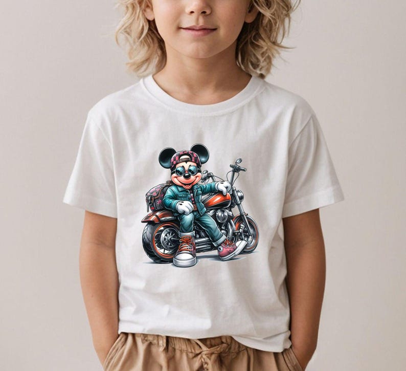 May include: White t-shirt with a cartoon image of Mickey Mouse wearing sunglasses and a hat, riding a motorcycle.