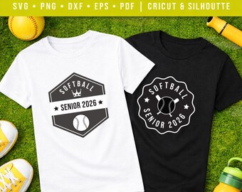 Könnte beinhalten: Zwei T-Shirts, eines weiß und eines schwarz, mit Softball-Designs. Das weiße Shirt zeigt eine Softball-Grafik mit dem Text "SOFTBALL SENIOR 2026". Das schwarze Shirt hat ein ähnliches Design. Ein Softball, ein Schläger und andere Sportgeräte sind im Hintergrund.