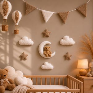 Op de afbeelding: Een muurdecoratieset voor de kinderkamer met een teddybeerthema. Inclusief luchtballonnen, wolken, sterren en een halve maan met een teddybeer. Het kleurenpalet is zacht, met beige, bruine en witte elementen, wat een gezellige sfeer creëert.