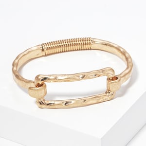 May include: A gold-toned metal bracelet featuring a textured, hammered finish. The design includes a central rectangular link element and a coiled spring section that allows for flexibility, creating a continuous circular band structure.