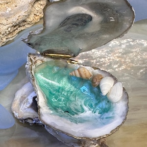 May include: A set of three ceramic mugs with a speckled, matte finish. The mugs are in shades of cream, light gray, and dark gray. Each mug has a simple, modern design, perfect for coffee or tea.