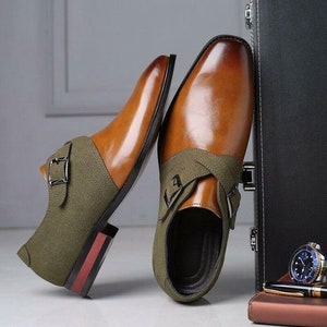 May include: A pair of brown leather dress shoes with green suede accents and buckle closures. The shoes have a polished finish and a classic design.