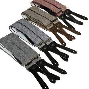 Könnte beinhalten: Vier Paar Hosenträger in verschiedenen Farben und Mustern. Die Hosenträger sind aus einem strukturierten Stoff gefertigt und haben schwarze Lederclips.