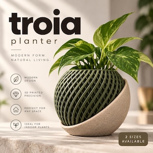 May include: A Troia planter featuring a spherical, olive green, 3D-printed lattice inner pot nested within a smooth, beige, semi-circular outer base. A green and yellow variegated pothos plant grows from the top. Text includes Troia planter, Modern form, Natural living, Modern design, 3D printed precision, Perfect for any space, Ideal for indoor plants, and 2 sizes available.