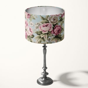 Peut inclure: Une lampe de table argent&eacute;e avec un abat-jour &agrave; motifs floraux. L'abat-jour pr&eacute;sente un fond bleu clair avec des roses roses et vertes.