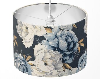 May include: A white and blue floral patterned lampshade with a white cord and a silver ceiling fixture.