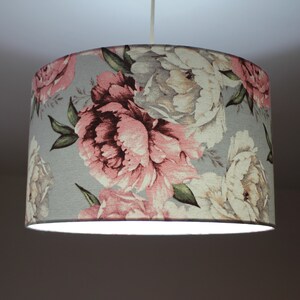 K&ouml;nnte beinhalten: Ein grauer Lampenschirm mit einem floralen Muster aus rosa und wei&szlig;en Pfingstrosen.