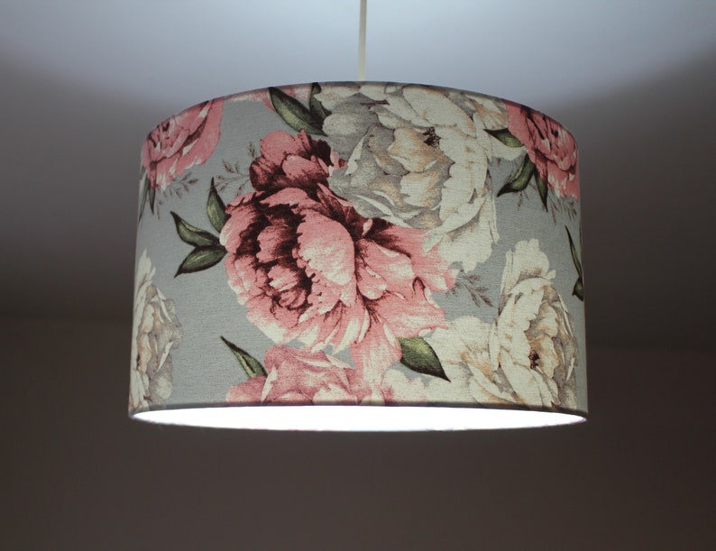 K&ouml;nnte beinhalten: Ein grauer Lampenschirm mit einem floralen Muster aus rosa und wei&szlig;en Pfingstrosen.