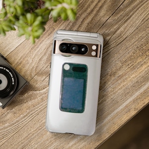 Puede incluir: Un teléfono móvil plegable blanco con un borde dorado y una lente de cámara negra. El teléfono tiene una pequeña pantalla en la parte delantera.