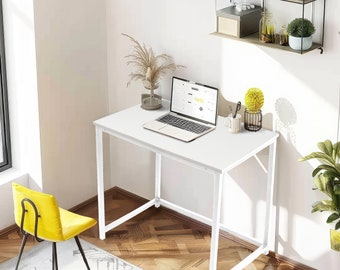 May include: White computer desk with a laptop, a potted plant, and a pencil holder on the surface. The desk has a white metal frame and is sitting on a wood floor.