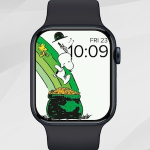May include: A black smartwatch displays a colorful cartoon scene of Snoopy and Woodstock on a rainbow, with a pot of gold. The time is 10:09, and the date is Friday the 23rd. The watch has a black band.
