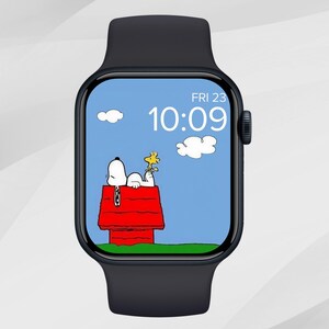 Puede incluir: Un reloj inteligente negro con un dise&ntilde;o de dibujos animados de Snoopy y Woodstock en la pantalla. La esfera del reloj muestra la hora 10:09 y la fecha viernes 23. El fondo es un cielo azul con nubes blancas.