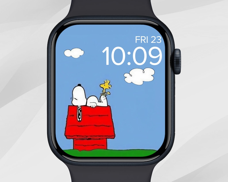 Puede incluir: Un reloj inteligente negro con una esfera de Snoopy y Woodstock. Snoopy est&aacute; acostado en su caseta roja con Woodstock. La hora es 10:09 y la fecha es viernes 23. Dos nubes blancas en el cielo azul.