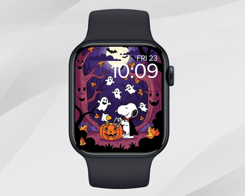 May include: A black smartwatch displaying a Halloween-themed graphic. The screen shows Snoopy in a Halloween scene with ghosts, a pumpkin, and a full moon. The time is 10:09, and the date is Friday, the 23rd.