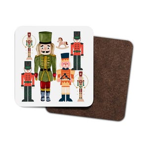 Op de afbeelding: Een vierkante onderzetter met een feestelijk ontwerp. Het heeft illustraties van notenkrakers in verschillende uniformen, een schommelpaard en decoratieve elementen. De onderzetter heeft een witte achtergrond en een bruine kurken achterkant.