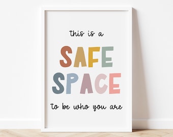 May include: A white framed print with the text "this is a SAFE SPACE to be who you are". The word "SAFE" is in rainbow colors.