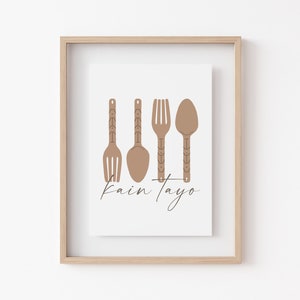 May include: A framed print with a minimalist design featuring four brown utensils, a fork, a spoon, and two spoons, with the text "kain tayo" below.