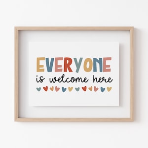 Puede incluir: Una impresión enmarcada con el texto "EVERYONE is welcome here" en letras de colores con una fila de corazones de colores debajo.