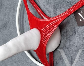 May include: Red shiny thong underwear with a ring detail. The underwear is displayed on a white hanger.