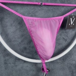 Può includere: Intimo in rete rosa con bordino in raso e un piccolo cartellino con la scritta "M".