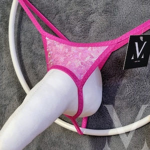 Può includere: Lingerie rosa con paillettes, con un cinturino in tessuto bianco e un'etichetta bianca con la lettera "M" su di essa.