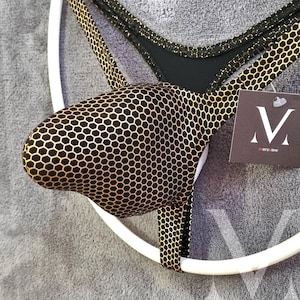 Könnte beinhalten: Schwarz-goldene Unterwäsche mit Wabenmuster. Die Unterwäsche wird auf einem weißen Kleiderbügel präsentiert. Ein Etikett mit dem Logo "mensview" ist angebracht.