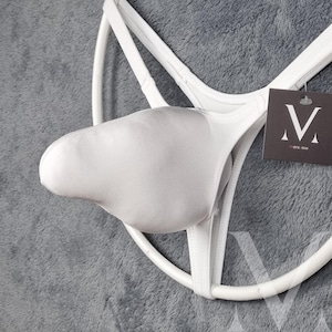 Könnte beinhalten: Weiße Unterwäsche mit einem stützenden Beutel und einem String-Rücken. Das Kleidungsstück hat ein minimalistisches Design mit einem Etikett mit der Aufschrift "Mers-low". Die Unterwäsche ist aus einem weichen, glatten Material gefertigt.