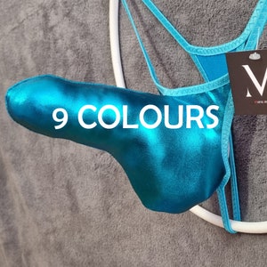 May include: A turquoise metallic thong with the text "9 COLOURS" in white. The thong is hanging on a white hanger. A tag with the brand name "M" is attached to the garment.
