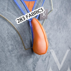 Könnte beinhalten: Orangefarbene und blaue Dessous mit dem Text "283 FABRICS". Die Dessous haben einen Mesh-Stoff und eine blaue Paspel. Das Kleidungsstück wird auf einem goldfarbenen Kleiderbügel vor grauem Hintergrund präsentiert.