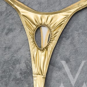 May include: Gold-colored lingerie with a keyhole cutout in the front.