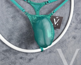 May include: A green mesh thong with a V-shaped front and adjustable straps. The thong is displayed on a white ring.