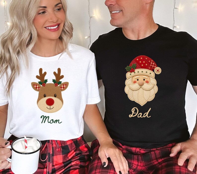 May include: A white t-shirt featuring a brown reindeer graphic with a red nose and the word Mom in green, and a black t-shirt featuring a Santa Claus graphic with a red hat and the word Dad in gold, both paired with red and black plaid pants.