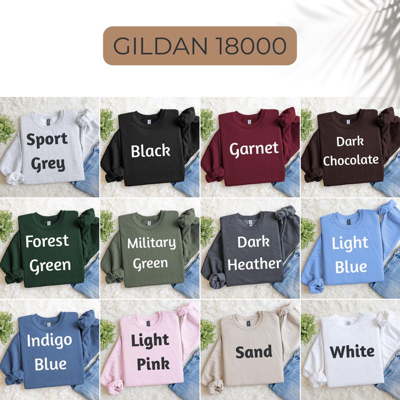 May include: A collection of twelve Gildan 18000 crewneck sweatshirts in various colors including Sport Grey, Black, Garnet, Dark Chocolate, Forest Green, Military Green, Dark Heather, Light Blue, Indigo Blue, Light Pink, Sand, and White.