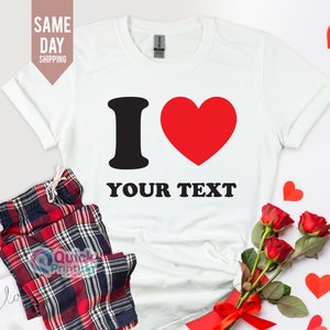 Könnte beinhalten: Weißes T-Shirt mit einem schwarzen "I" und einem roten Herzen. Der Text "YOUR TEXT" ist unter dem Herzen gedruckt.