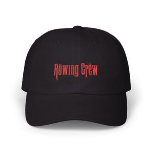 May include: Black baseball cap with a curved brim. The cap features the red text "Röwing Crëw" across the front. The hat is made of a soft material and has a classic, casual style.